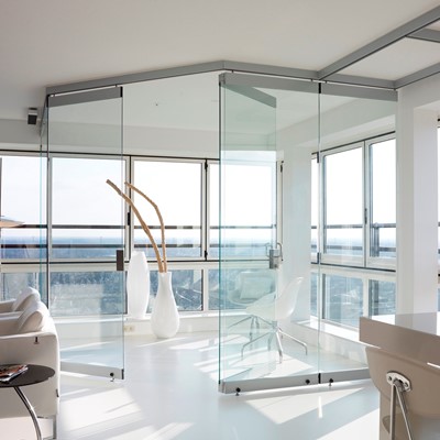 EEN GLASWAND MET GLAZEN SCHUIFDEUREN EN VOUWWANDEN